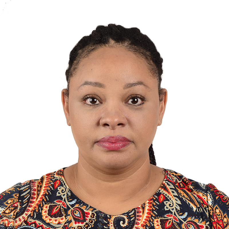 Portrait of a woman with braided hair wearing a colorful patterned top, looking directly at the camera with a neutral expression.