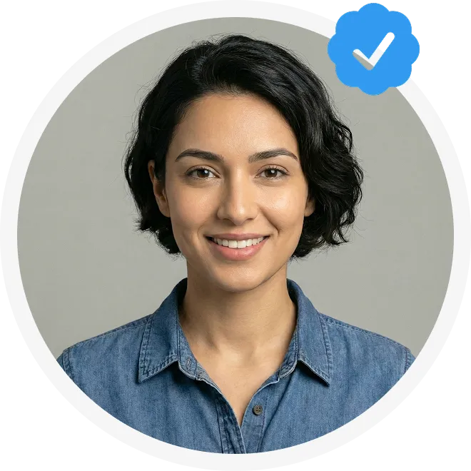 Smiling woman with short dark hair wearing a denim shirt, framed in a circular border with a blue verified checkmark icon.