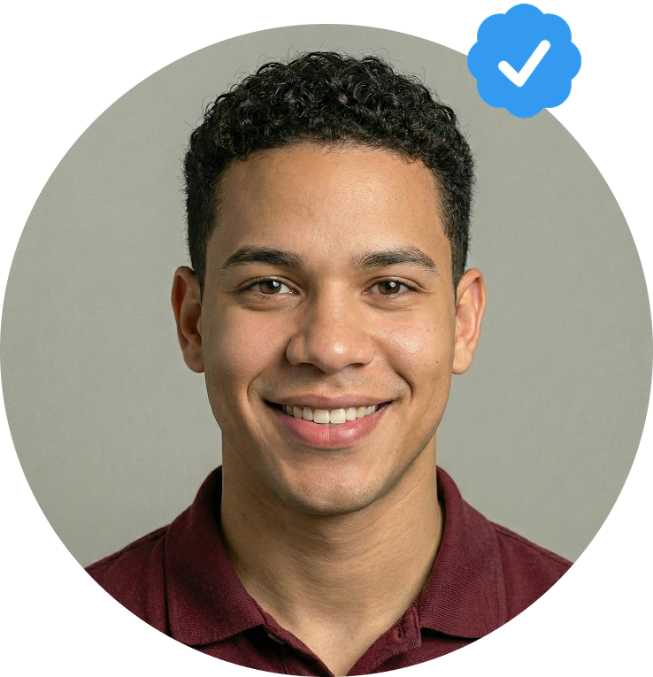 Portrait of a smiling young man with curly hair wearing a maroon shirt, with a blue verified checkmark badge at the upper right.