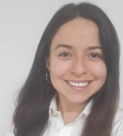 Young woman with long dark hair smiling against a plain light background.